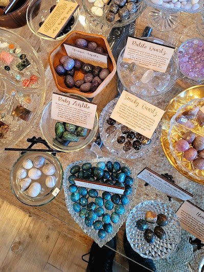 Display of crystal jewelry, tumbled stones, and carved gemstone pieces