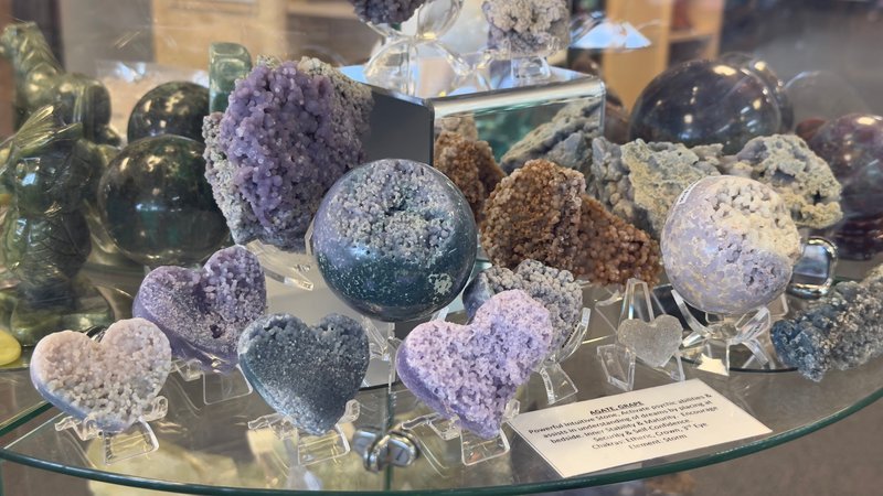 Display featuring crystal points, polished stones, and raw mineral specimens