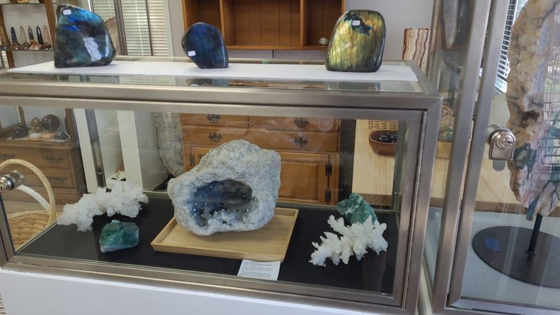 Display featuring crystal points, polished stones, and raw mineral specimens