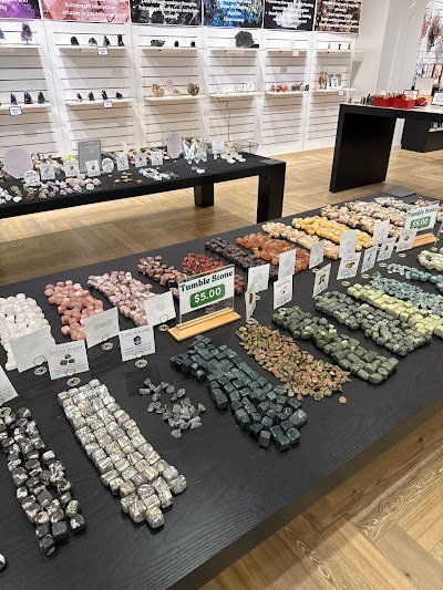 Display of crystal jewelry, tumbled stones, and carved gemstone pieces