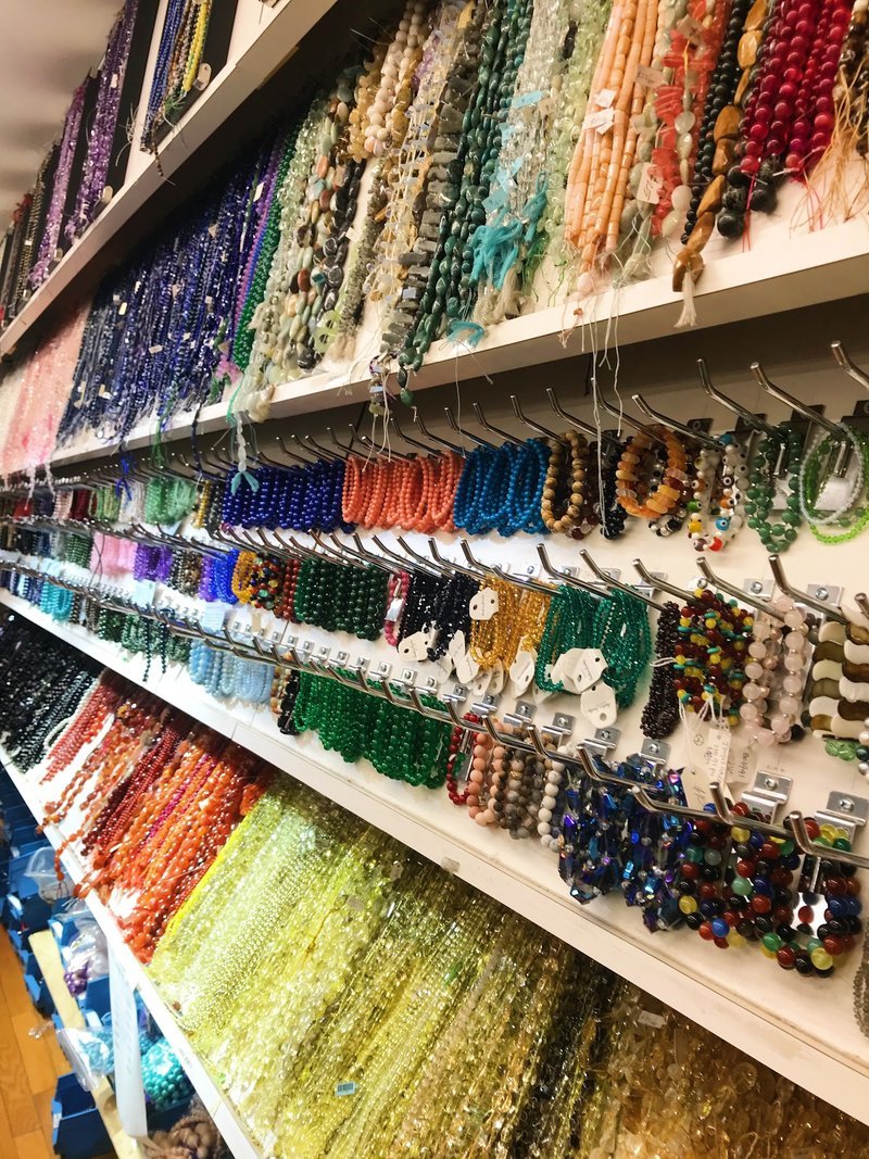 Display of crystal jewelry, tumbled stones, and carved gemstone pieces
