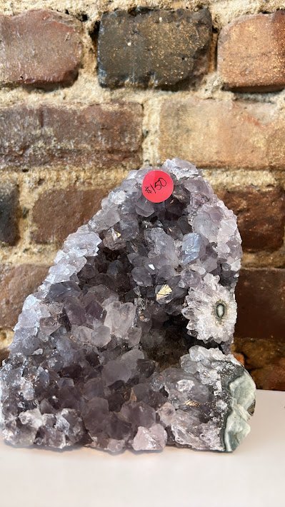 Shelving display featuring amethyst, quartz, and various crystal specimens