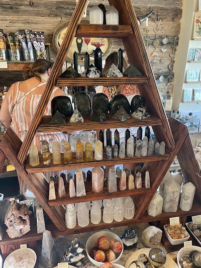 Display of crystal jewelry, tumbled stones, and carved gemstone pieces
