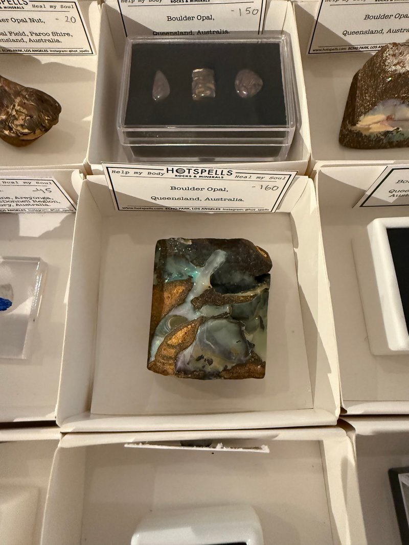 Display featuring crystal points, polished stones, and raw mineral specimens
