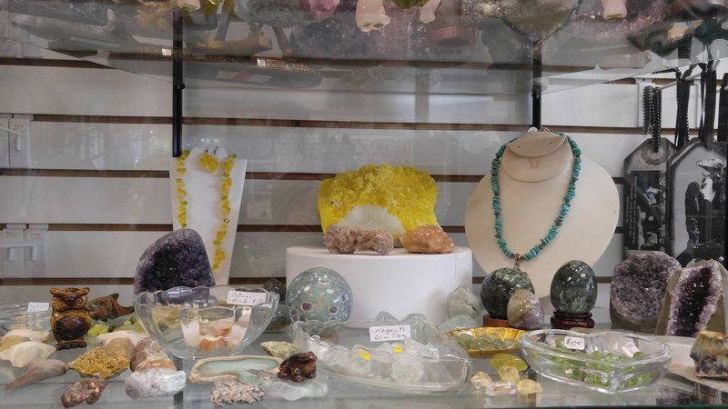 Shelving display featuring amethyst, quartz, and various crystal specimens