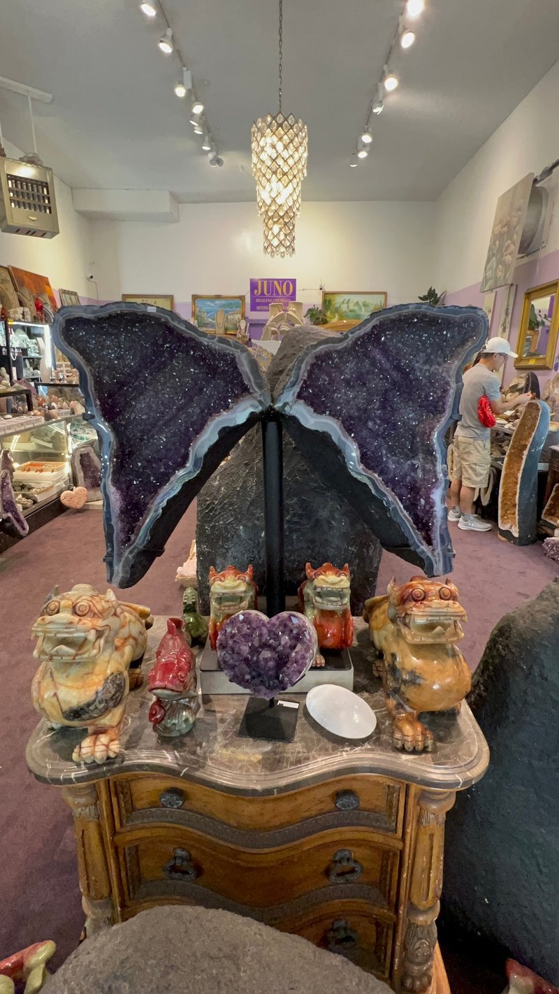 Shelving display featuring amethyst, quartz, and various crystal specimens