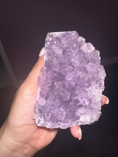 Shelving display featuring amethyst, quartz, and various crystal specimens