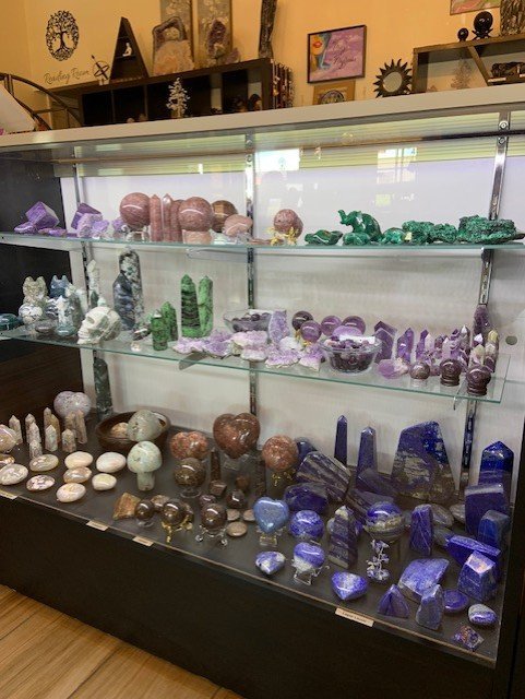 Shelving display featuring amethyst, quartz, and various crystal specimens