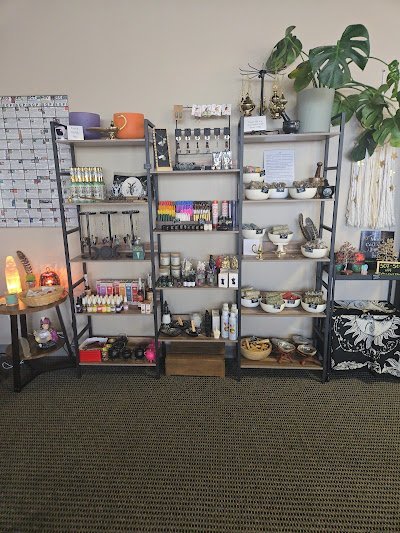 Store interior with metal shelves displaying mineral specimens, bracelets, and organized crystal inventory