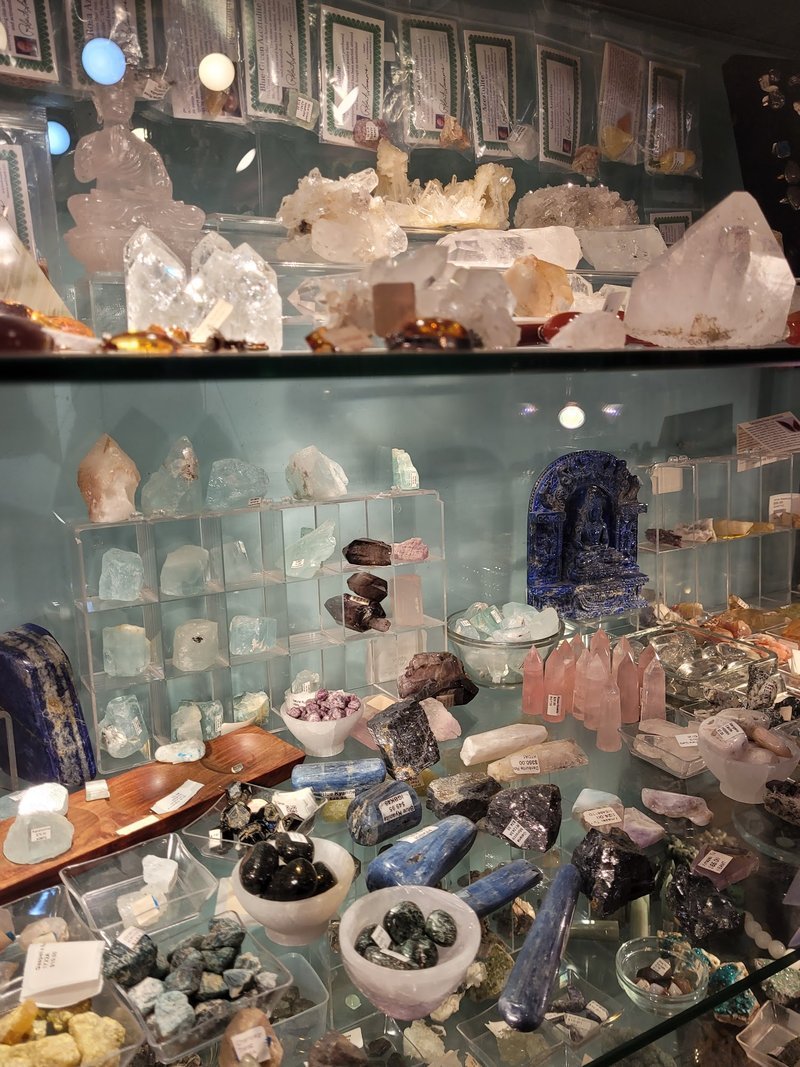 Shelving display featuring amethyst, quartz, and various crystal specimens
