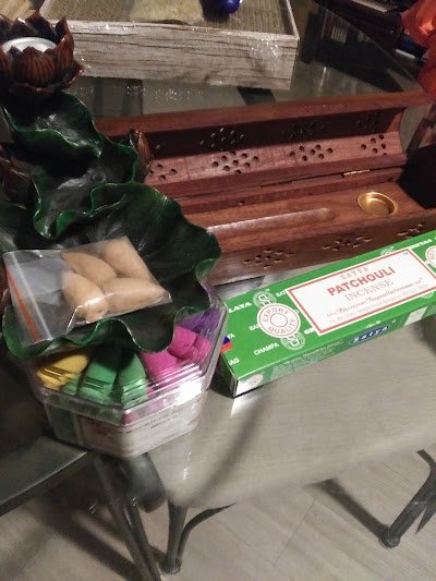 Incense display with patchouli boxes, resin burners, and spiritual accessories on wooden counter