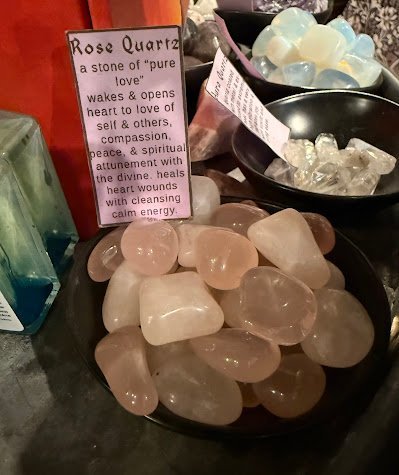Display of crystal jewelry, tumbled stones, and carved gemstone pieces