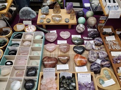 Shelving display featuring amethyst, quartz, and various crystal specimens