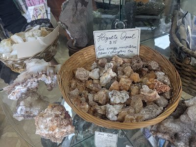 Display of crystal jewelry, tumbled stones, and carved gemstone pieces