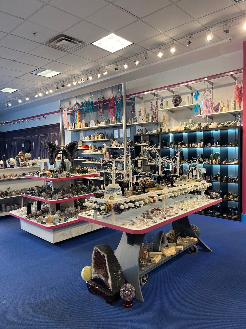 Shelving display featuring amethyst, quartz, and various crystal specimens