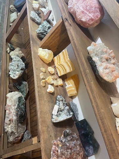 Wooden tray display with banded agate, tumbled stones, and raw crystal specimens