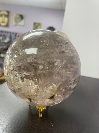 Large clear quartz crystal sphere on brass stand