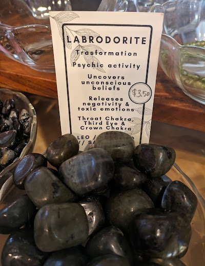 Tumbled labradorite specimens in labeled display bowl with healing properties description