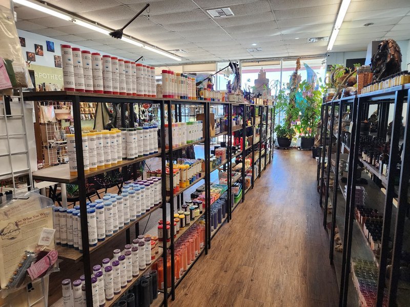 Spiritual shop interior with metal shelving displaying candles, herbs, and metaphysical products