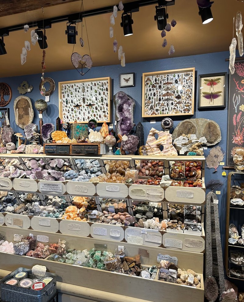 Shelving display featuring amethyst, quartz, and various crystal specimens