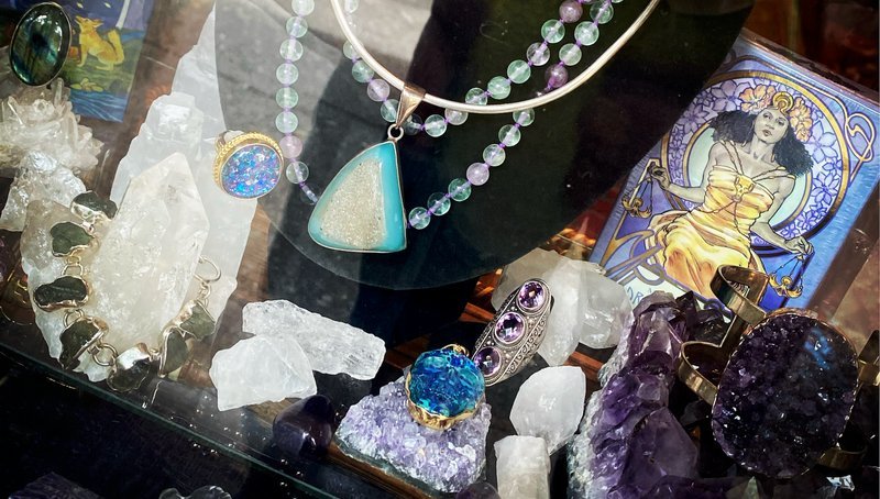 Shelving display featuring amethyst, quartz, and various crystal specimens