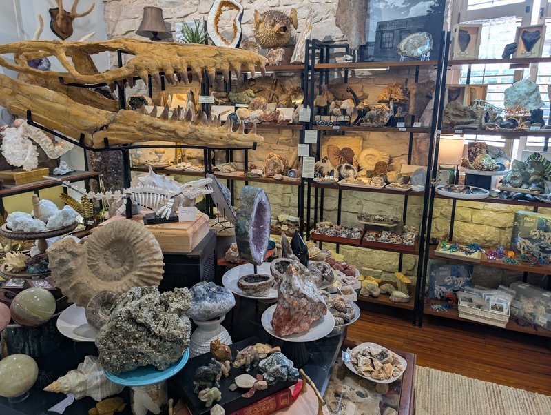 Shelving display featuring amethyst, quartz, and various crystal specimens