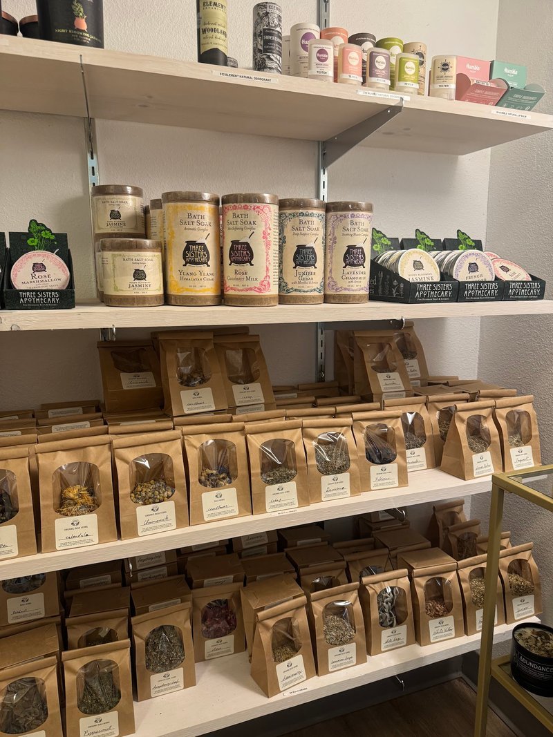White shelving display with bath salts, herbal products, and packaged herbs