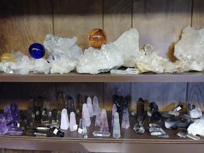 Shelving featuring chakra stones, healing crystals, and mineral specimens